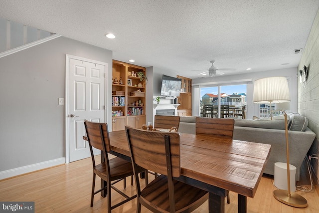 dining area with ceiling fan, a textured ceiling, and light hardwood / wood-style flooring