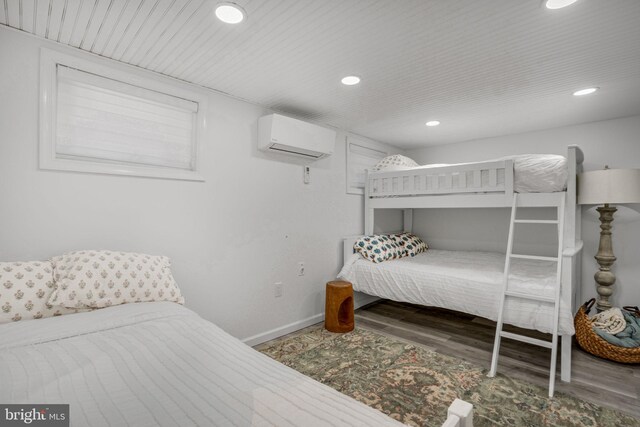 bedroom with wood-type flooring and an AC wall unit