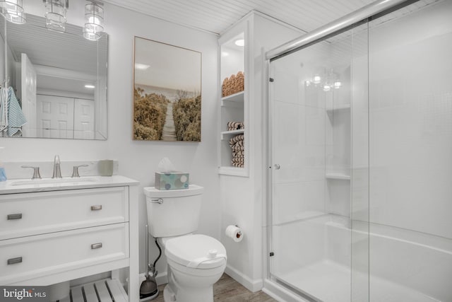 bathroom with vanity, toilet, a shower with door, and hardwood / wood-style floors