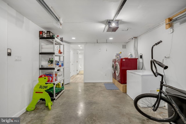 garage featuring a garage door opener, separate washer and dryer, and fridge