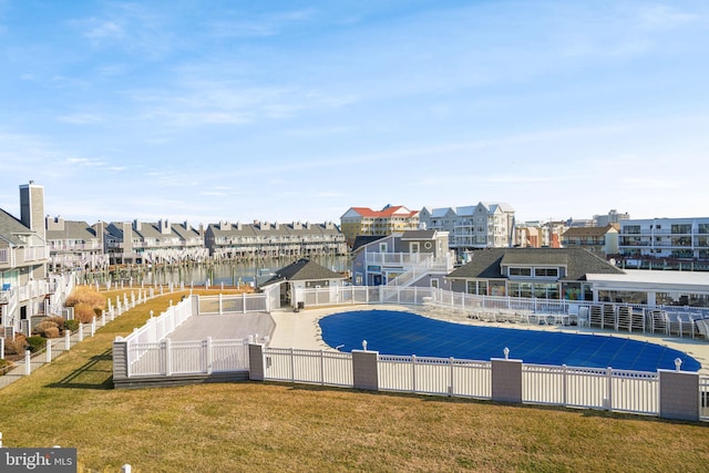 view of pool featuring a water view and a lawn