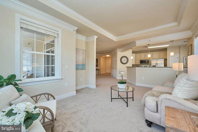 living area with baseboards, a raised ceiling, light colored carpet, and ornamental molding