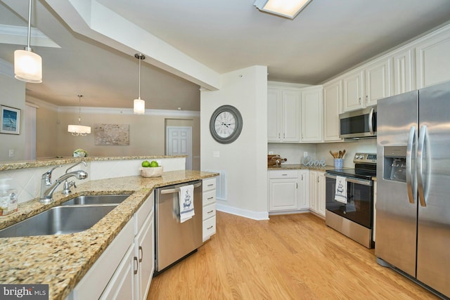 kitchen featuring a sink, tasteful backsplash, stainless steel appliances, white cabinets, and light wood finished floors