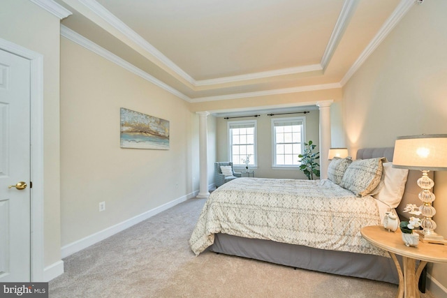 carpeted bedroom featuring baseboards, a tray ceiling, ornate columns, and ornamental molding