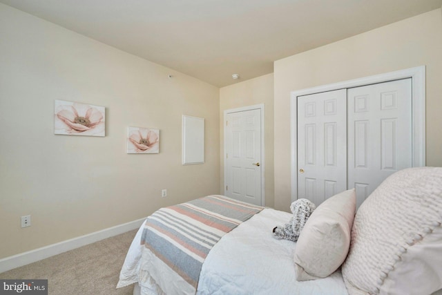 bedroom with a closet, baseboards, and carpet