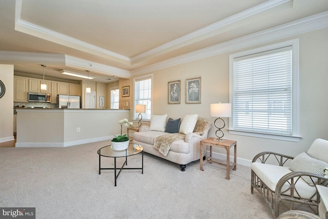 living area with a tray ceiling, light carpet, baseboards, and crown molding