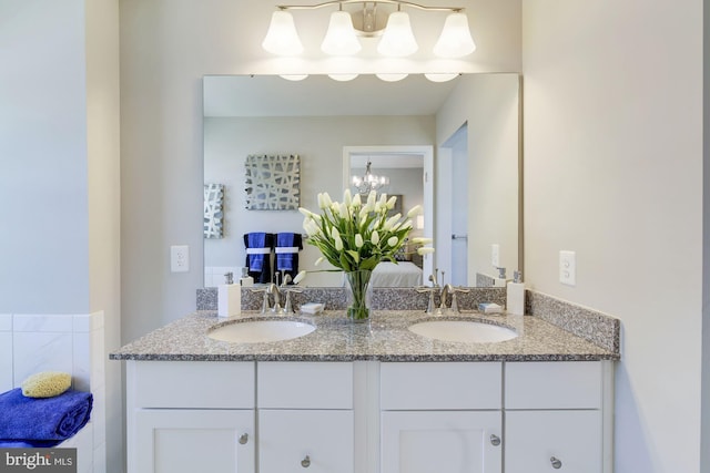 bathroom with an inviting chandelier and vanity