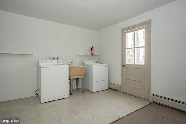 washroom with separate washer and dryer, sink, and baseboard heating