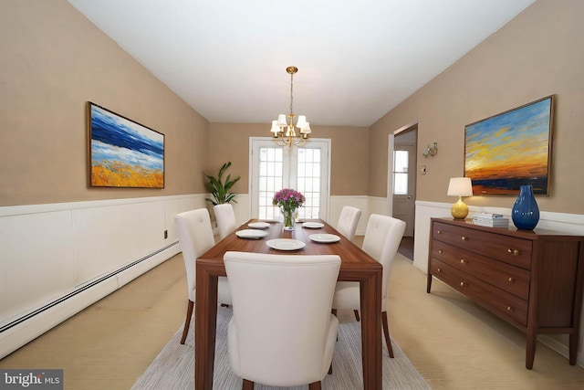 carpeted dining area featuring an inviting chandelier and a baseboard heating unit