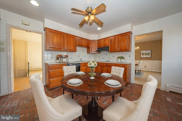 kitchen with decorative backsplash, ceiling fan with notable chandelier, black appliances, and baseboard heating