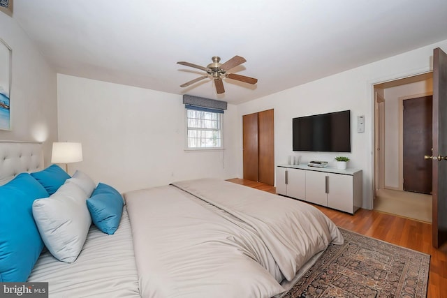 bedroom with ceiling fan, light wood-type flooring, and a closet