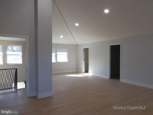 spare room featuring lofted ceiling and wood-type flooring