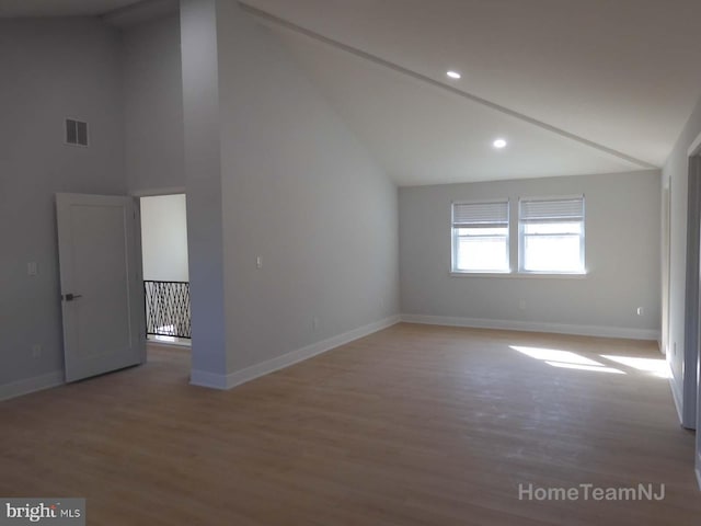 empty room with hardwood / wood-style flooring and high vaulted ceiling