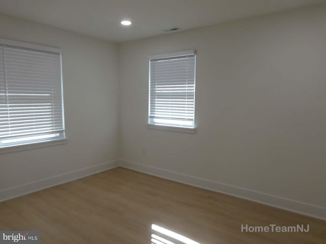 unfurnished room with wood-type flooring and plenty of natural light