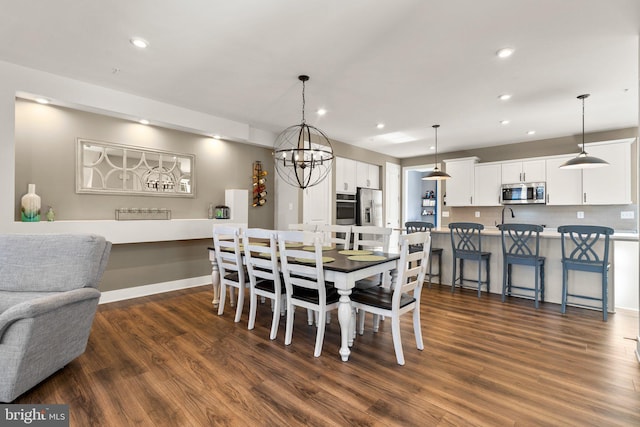 dining space featuring dark hardwood / wood-style floors and an inviting chandelier