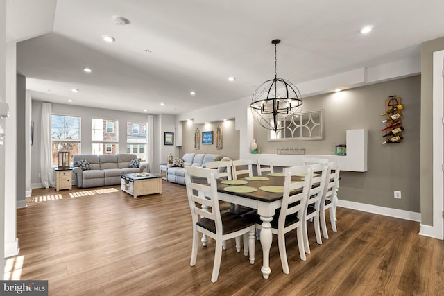 dining space with hardwood / wood-style floors and a chandelier