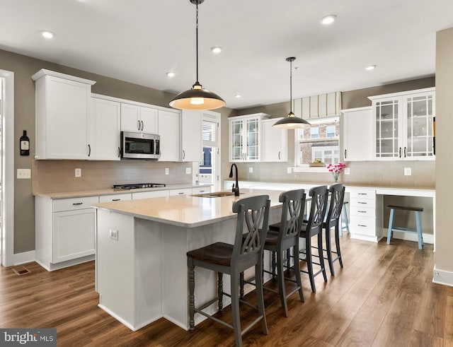 kitchen with white cabinetry, appliances with stainless steel finishes, a kitchen island with sink, and a wealth of natural light