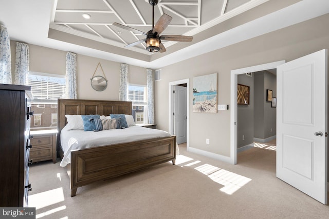 bedroom featuring ornamental molding, light colored carpet, ceiling fan, and a tray ceiling