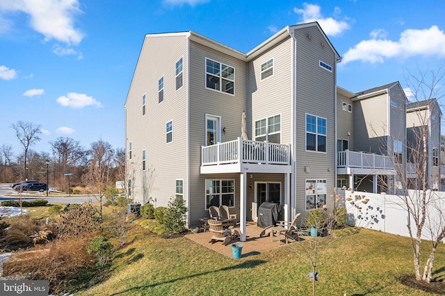 back of property with a yard and a patio area