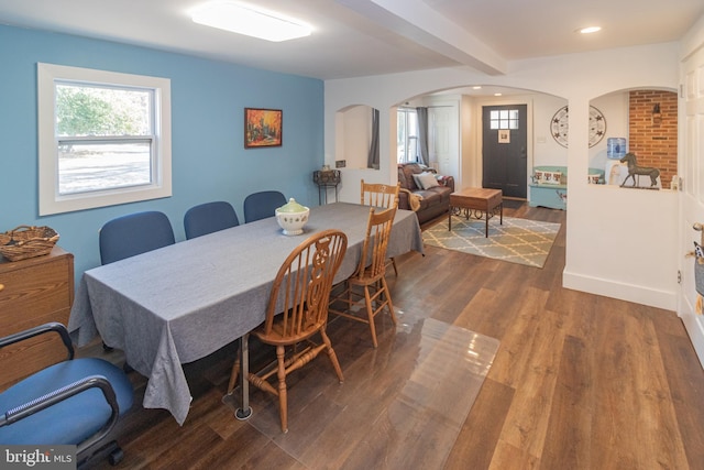 dining space featuring dark wood-type flooring and beamed ceiling