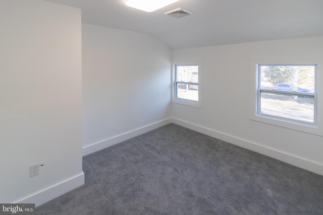 carpeted spare room with vaulted ceiling