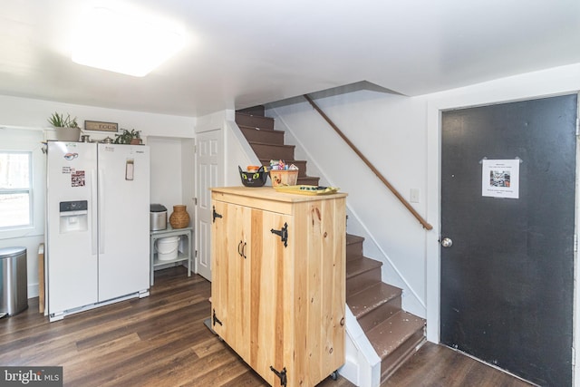 interior space with dark wood-type flooring and white refrigerator with ice dispenser