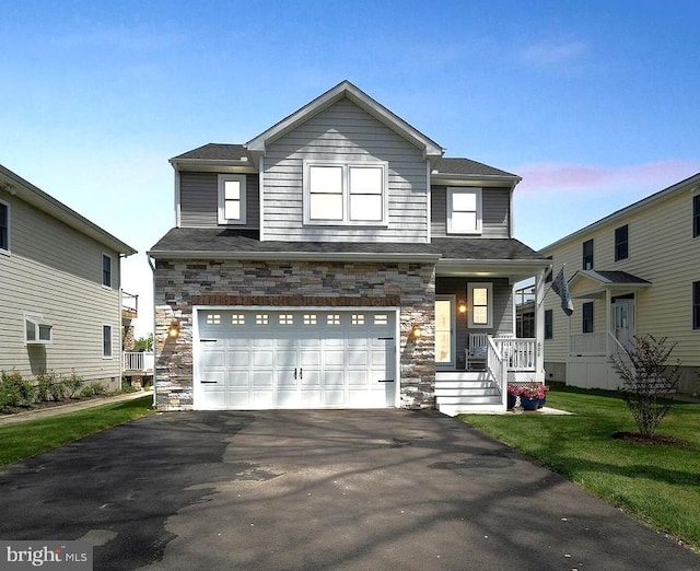 view of front of home with a garage, a porch, and a lawn