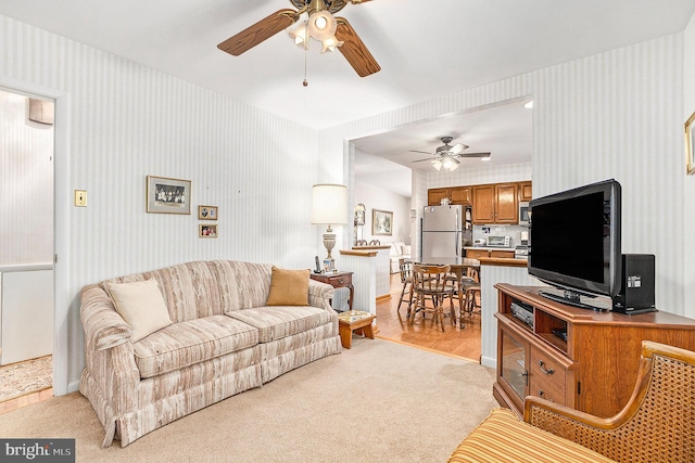 carpeted living room featuring ceiling fan