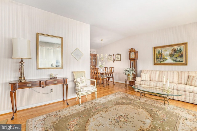 living room featuring wood-type flooring and vaulted ceiling