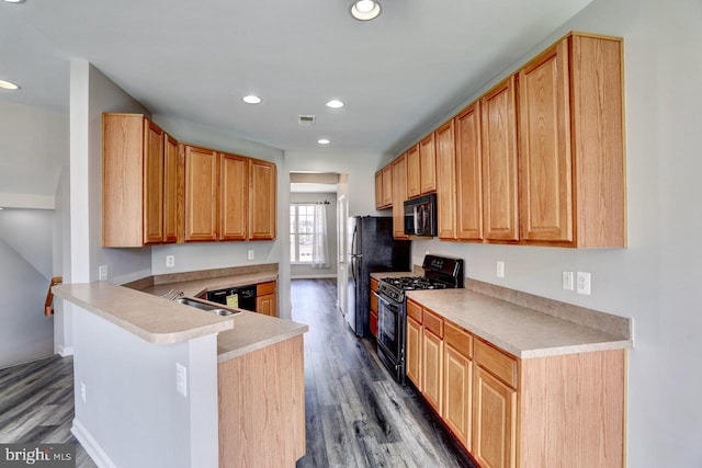 kitchen with dark hardwood / wood-style floors, black appliances, sink, kitchen peninsula, and light brown cabinets