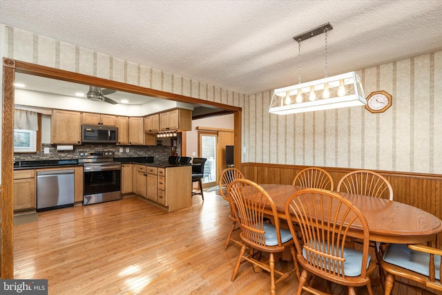 dining room featuring ceiling fan, light hardwood / wood-style floors, and a textured ceiling