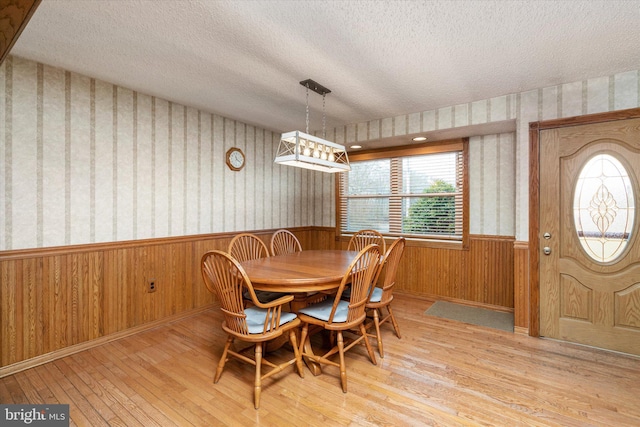 dining space featuring a textured ceiling and light wood-type flooring