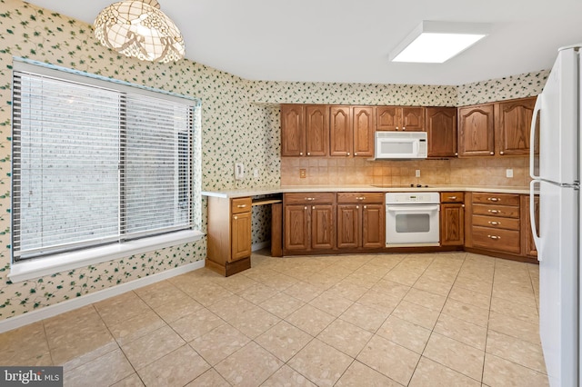 kitchen featuring pendant lighting, light tile patterned floors, white appliances, and tasteful backsplash