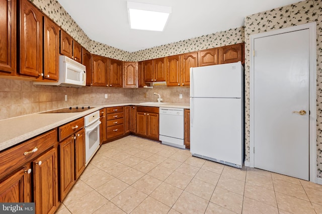 kitchen featuring sink, light tile patterned floors, white appliances, and decorative backsplash