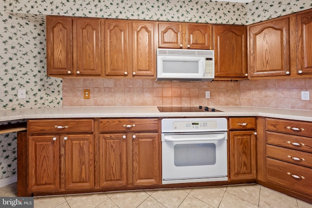 kitchen with white appliances, decorative backsplash, and light tile patterned flooring