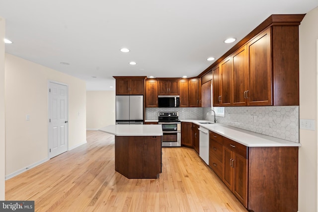 kitchen with tasteful backsplash, light hardwood / wood-style flooring, stainless steel appliances, and a kitchen island