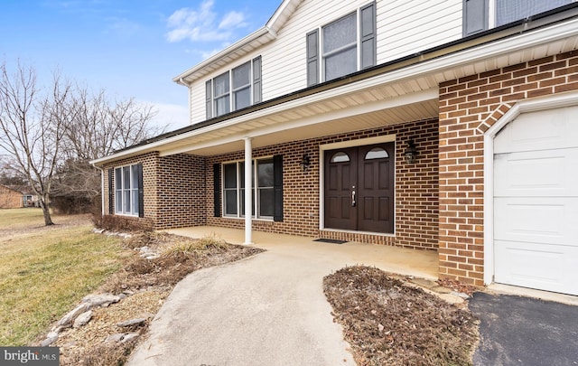 view of exterior entry with a porch and a garage