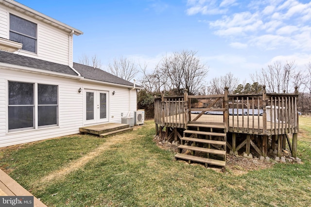 view of yard with french doors, a deck, and ac unit