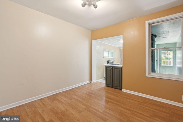 spare room with a textured ceiling and light wood-type flooring