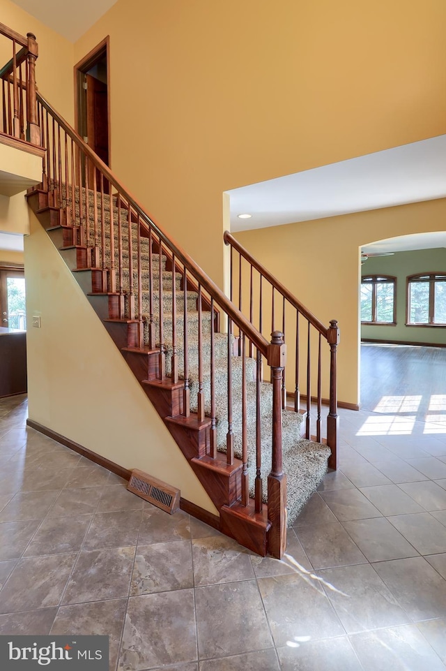 stairs featuring a high ceiling, plenty of natural light, and visible vents
