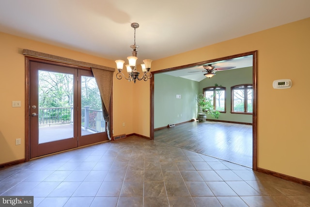 tiled spare room with plenty of natural light, baseboards, and ceiling fan with notable chandelier