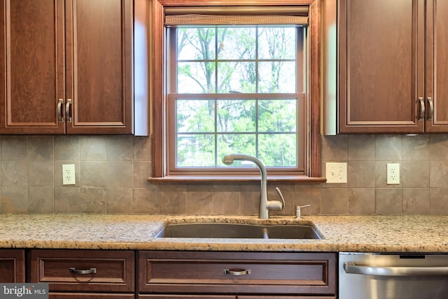 kitchen with stainless steel dishwasher, tasteful backsplash, a healthy amount of sunlight, and a sink