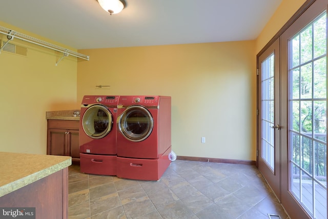 laundry room featuring baseboards, washer and dryer, and cabinet space