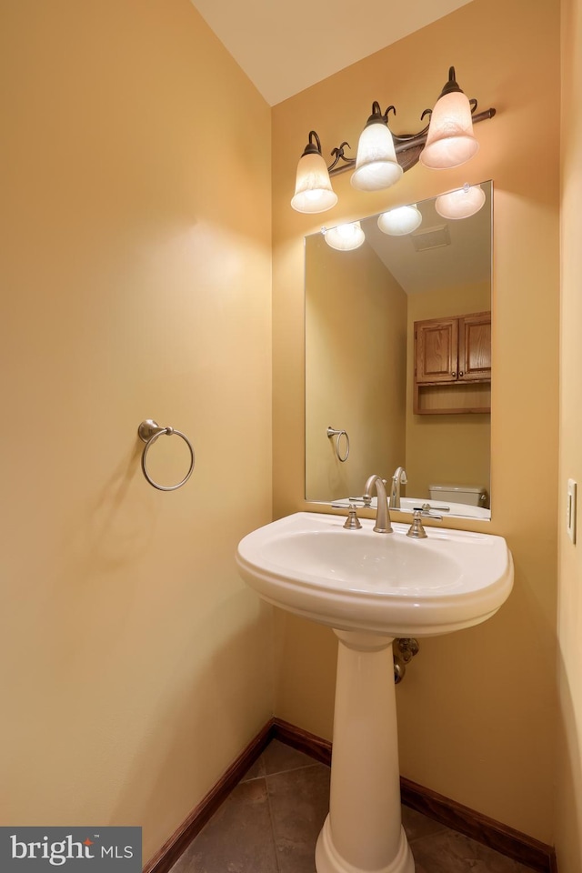 bathroom with tile patterned floors, baseboards, and a sink
