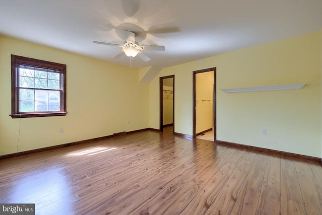 unfurnished room featuring a ceiling fan, baseboards, visible vents, and wood finished floors