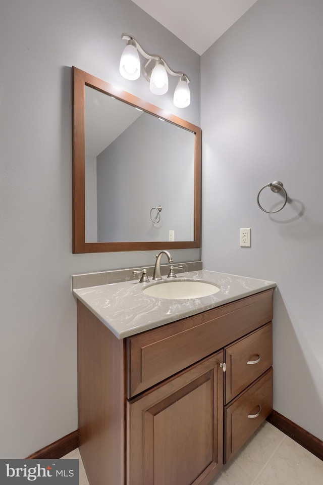 bathroom with baseboards, marble finish floor, and vanity