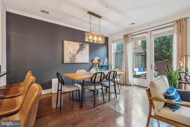 dining room featuring ornamental molding and dark hardwood / wood-style floors