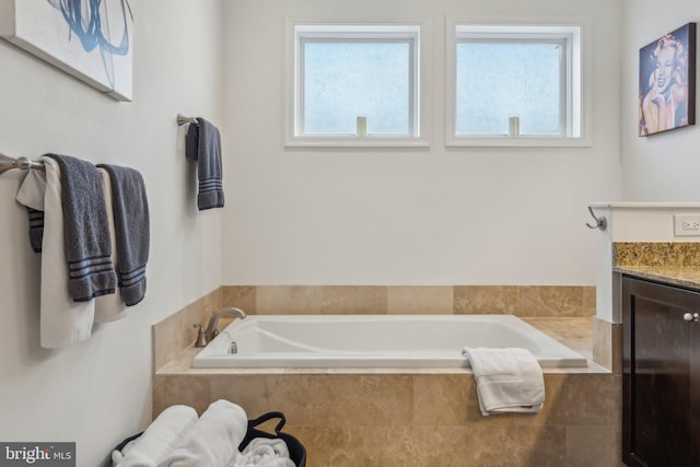 bathroom with vanity and a relaxing tiled tub