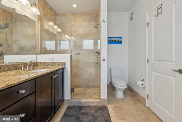 bathroom with vanity, a shower with shower door, and toilet