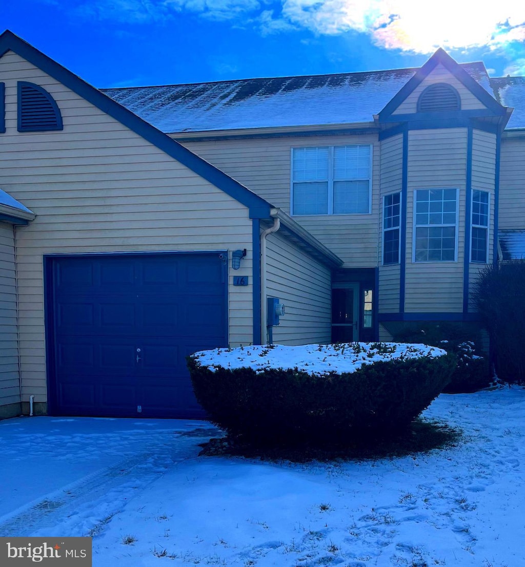 view of snow covered exterior featuring a garage